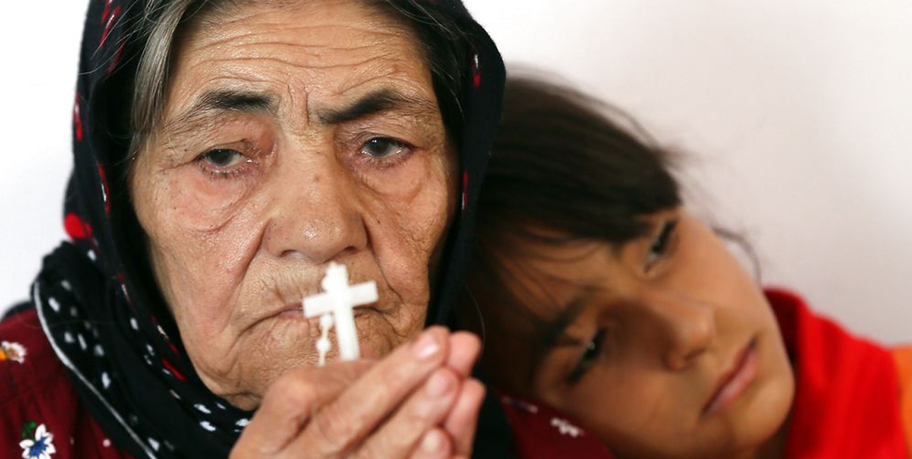 En irakisk kvinde beder sammen med sit barnebarn. Irak er et af de lande, hvor mange kristne har måttet flygte fra voldelige islamistiske ekstremister. Foto: Karim Sahib/Scanpix