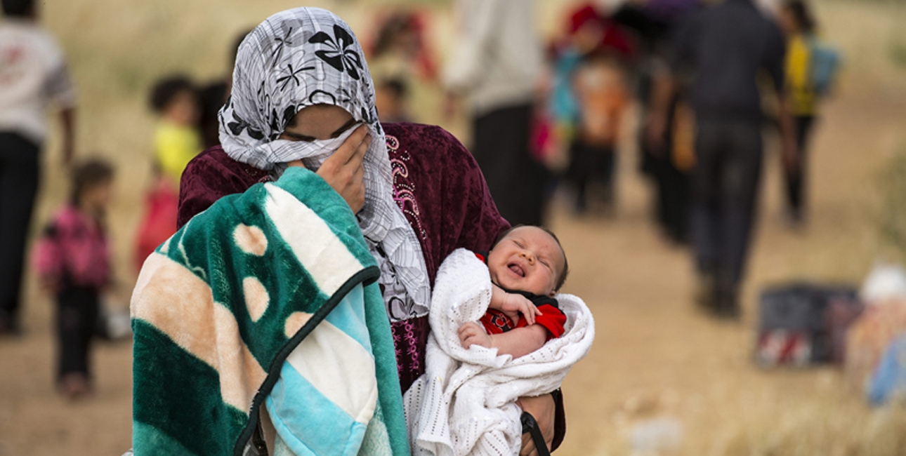Mor er på flugt fra Syrien med sit barn på armen. Foto: UBS. 