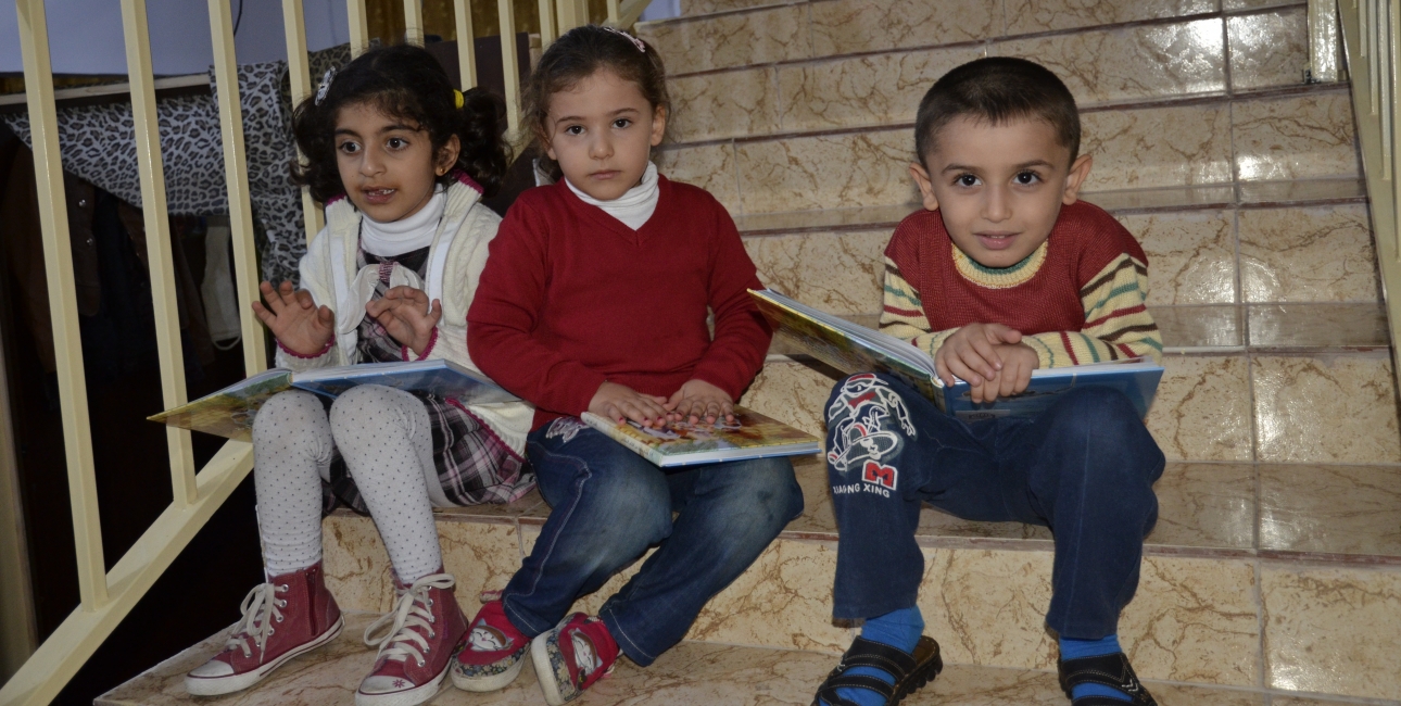 De syriske flygtningebørn får omsorg i Jordans kirker. Her har de sat sig til at læse i nogle børnebibler. Foto: Tobias Keil, Det Tyske Bibelselskab