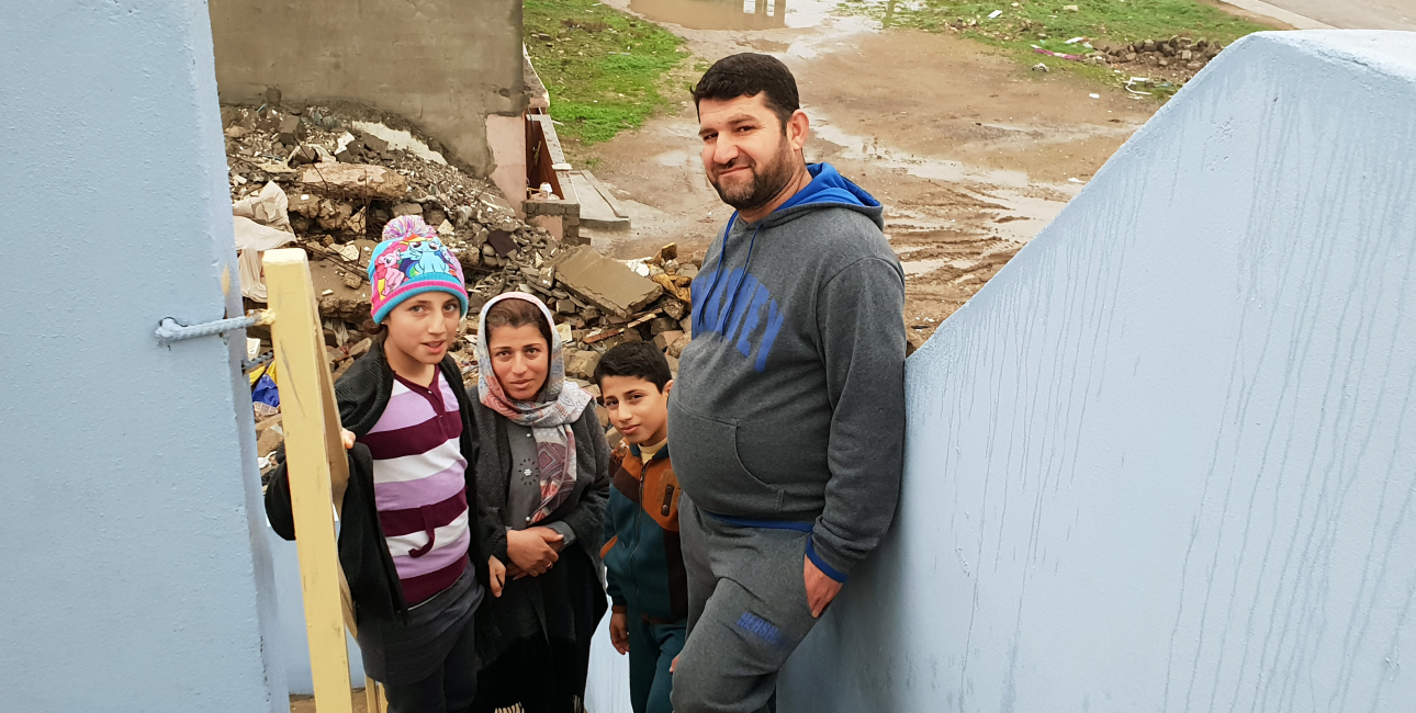 Lara , Ihsan og deres to børn foran deres ødelagte hus. Foto: Lina Musharbash og Andrea Rhodes