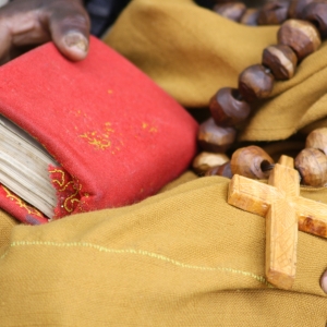 Bibel og kors i skødet. Foto: Grace Smith, United Bible Societies