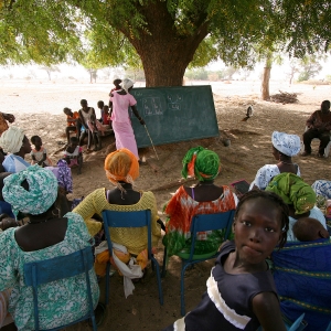 En gruppe mennesker modtager læseundervisning i skyggen i Tattaguine, Senegal. Foto Joaquim Dassonville / UBS. 
