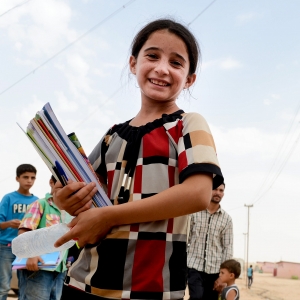 Pige fra Mellemøsten med bøger under armen. Foto: Sat-7