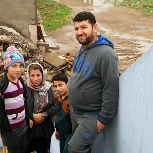 Lara , Ihsan og deres to børn foran deres ødelagte hus. Foto: Lina Musharbash og Andrea Rhodes