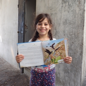 Maria fra Syrien er glad for sin børnebibel. Foto: UBS.