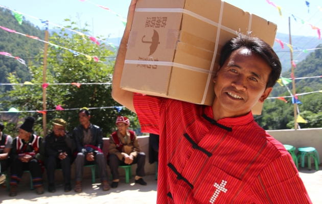 Wa-biblerne blev båret med smil på læben. Til trods for flere problemer fik bjergstammen i Kina endelig en bibel på deres eget sprog. Foto: De Forenede Bibelselskaber.