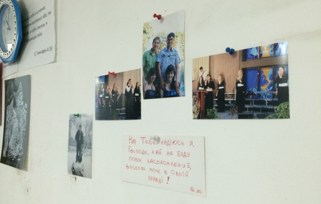 Billederne, som Alesjas familie nåede at få med hjemmefra, da de flygtede, hænger på væggen i det lille kælderværelse under Grace Evangelical Church, hvor de bor. Foto: Inge Haandsbæk Jensen