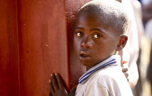 Mange børn i Swaziland får kun ét måltid om dagen. 69% af befolkningen lever i fattigdom. 1/4 del af Swazilands befolkning sulter. Drengens måltid indtages på skolen. Hvis ellers madvognen når frem. Foto: Adam Garff. 