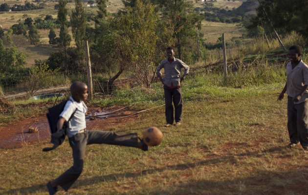 Børnene spiller ofte fodbold på bare fødder og skærer sig på den stenede plæne. Når børnene får renset deres sår, er lærerne nervøse for at blive smittet. Der er nemlig ingen engangshandsker på skolen. Foto: Adam Garff. 