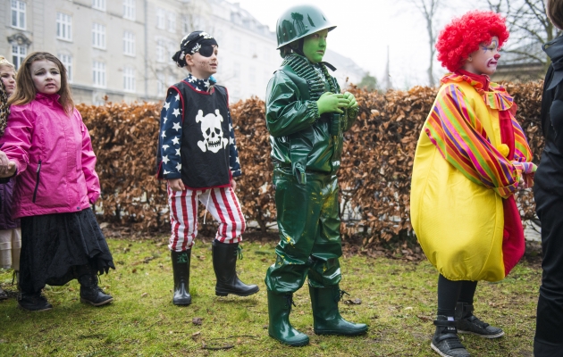 En pirat, en camoufleret soldat og en rødhåret klovn står i kø til tøndeslagning. Foto: Søren Bidstrup/Scanpix.