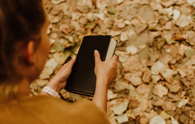 Kvinde med bibel. Foto: Unsplash.