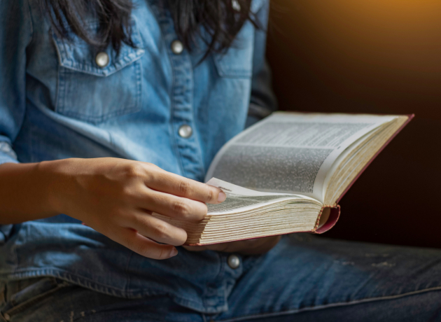 En kvinde læser i Bibelen. Foto: NIKCOA / Shutterstock.com.